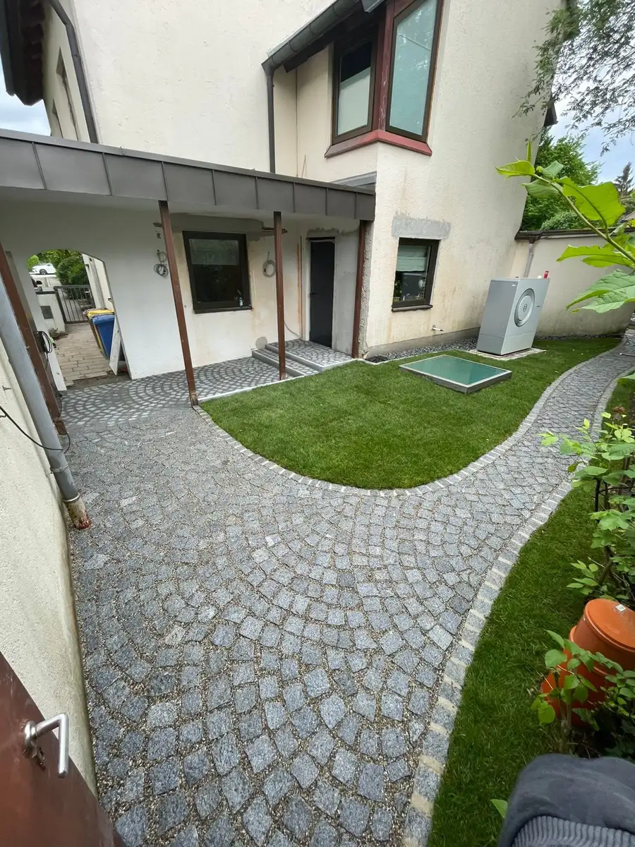 Derselbe Innenhof nach dem Pflastern, mit neuer Rasenfläche