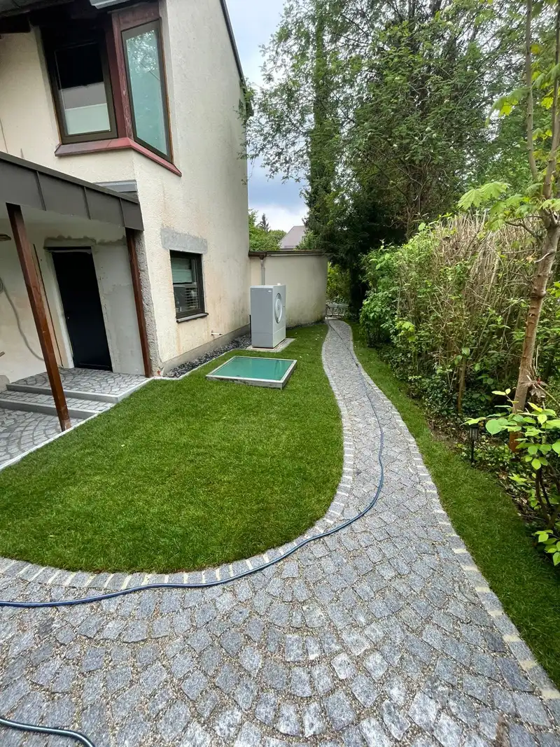 Rasenfläche mit geschwungenem Kleinpflasterweg