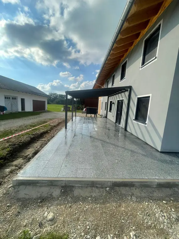 Geflieste Terrasse mit Überdachung an einem Wohnhaus