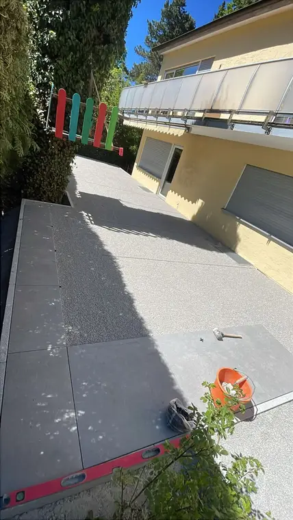 Neu verlegte Terrassenplatten an einem Wohnhaus mit Werkzeug
