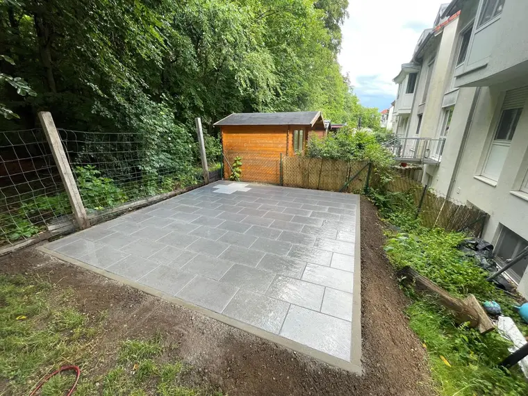 Neu gepflasterte Terrassenfläche im Garten vor einer Hütte