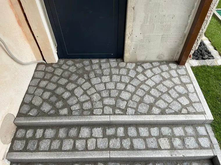 Neu verlegtes Kopfsteinpflaster vor einer Hauseingangstür