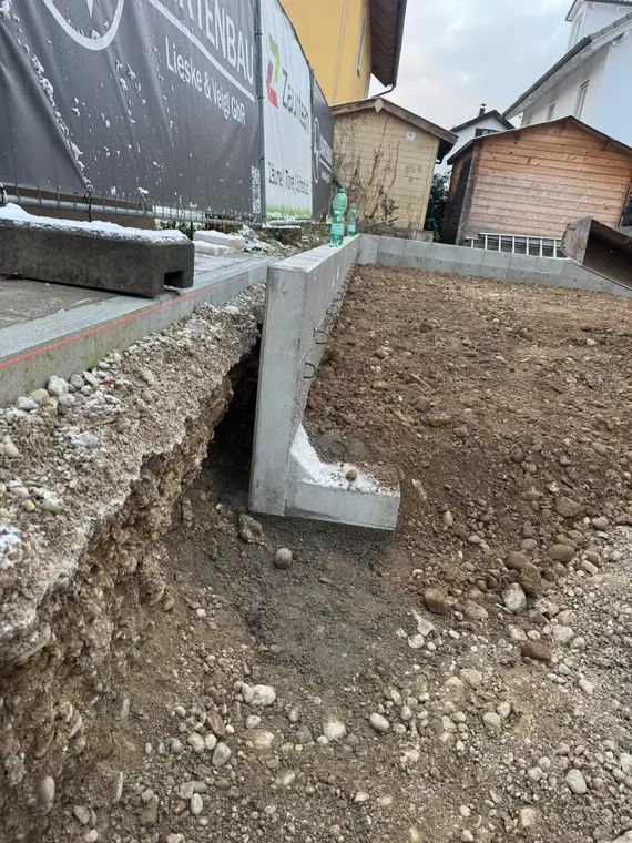 Eingesetzte L-Steine an einer Baustelle mit Erdaushub