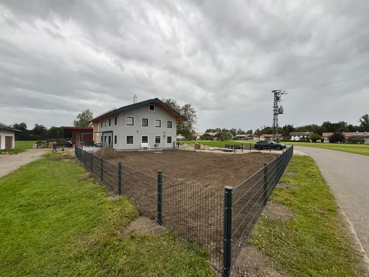 Eingezäunter Gartenbereich vor einem zweigeschossigen Haus